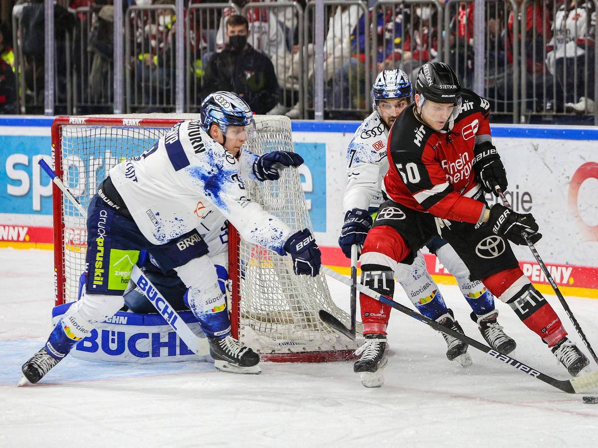 Simon Gnyp (Ingolstadt, links) und Kollege Colton Jobke im Duell um den Puck mit Alexander Oblinger (Kölner Haie).