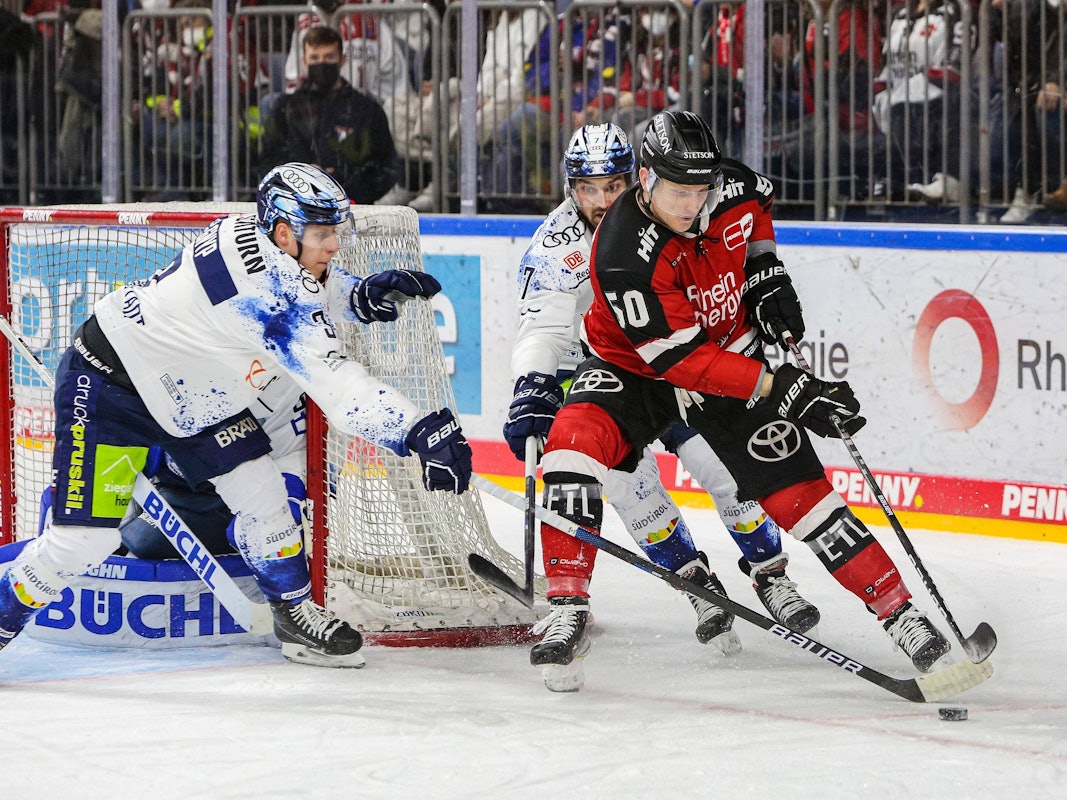 Simon Gnyp (Ingolstadt, links) und Kollege Colton Jobke  im Duell um den Puck mit Alexander Oblinger (Kölner Haie).