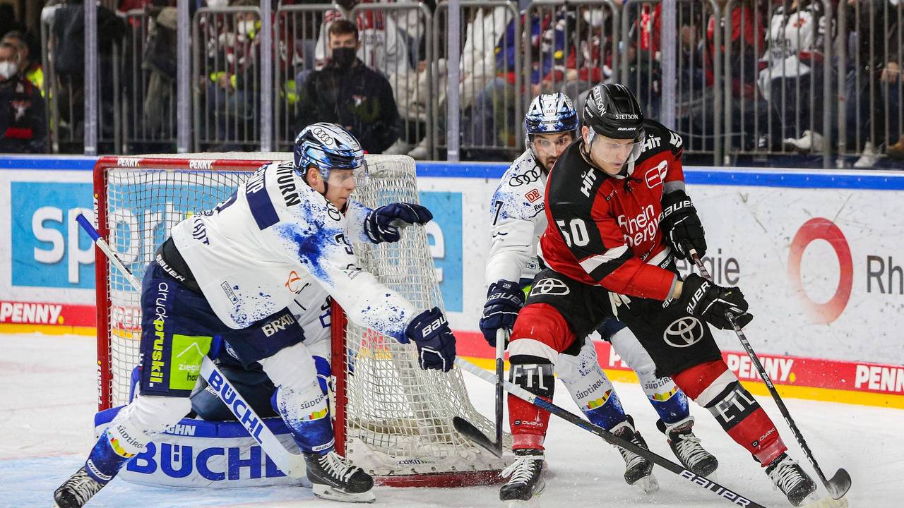 Simon Gnyp (Ingolstadt, links) und Kollege Colton Jobke im Duell um den Puck mit Alexander Oblinger (Kölner Haie).