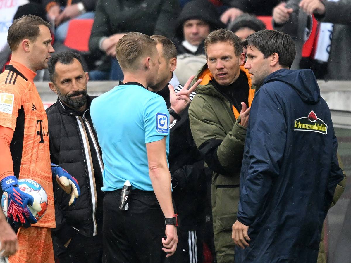 Schiedsrichter Christian Dingert (M.) spricht mit Bayern-Trainer Julian Nagelsmann (2.v.r.) und Freiburgs Co-Trainer Florian Bruns (r.) über den Wechselfehler der Münchner im Spiel beim SC Freiburg.