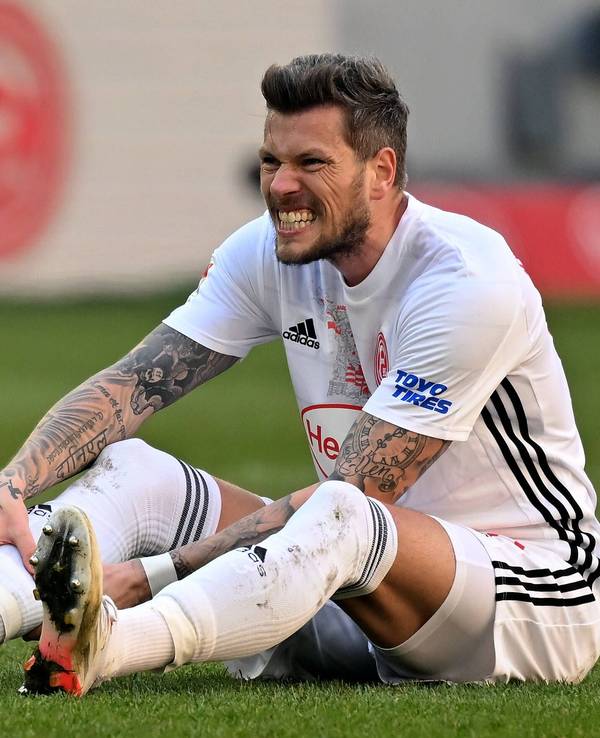Daniel Ginczek (Düsseldorf) sitzt auf dem Rasen.