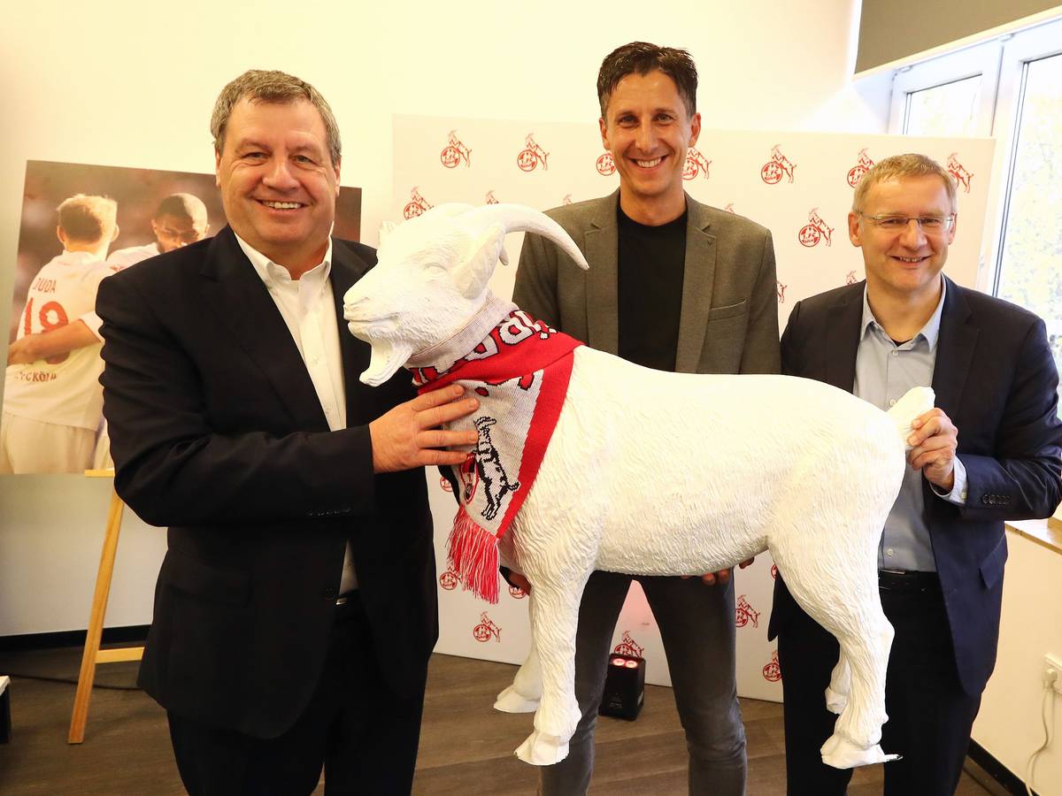 Christian Keller hält beim 1. FC Köln mit Werner Wolf und Eckhard Sauren einen Geißbock.