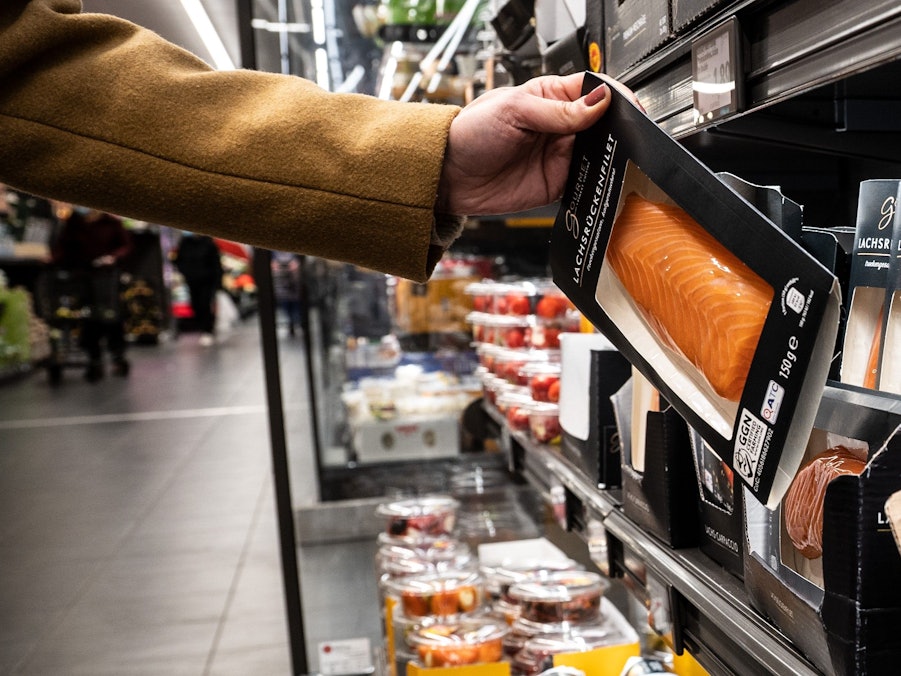 Aldi macht es vor, andere Discounter und Supermärkte werden nachziehen: Die Preise für viele Produkte steigen. Lebensmittel werden immer teurer. Eine Frau nimmt in unserem Archivbild von 2021 in einer Aldi-Filiale ein Produkt aus der Kühlung.