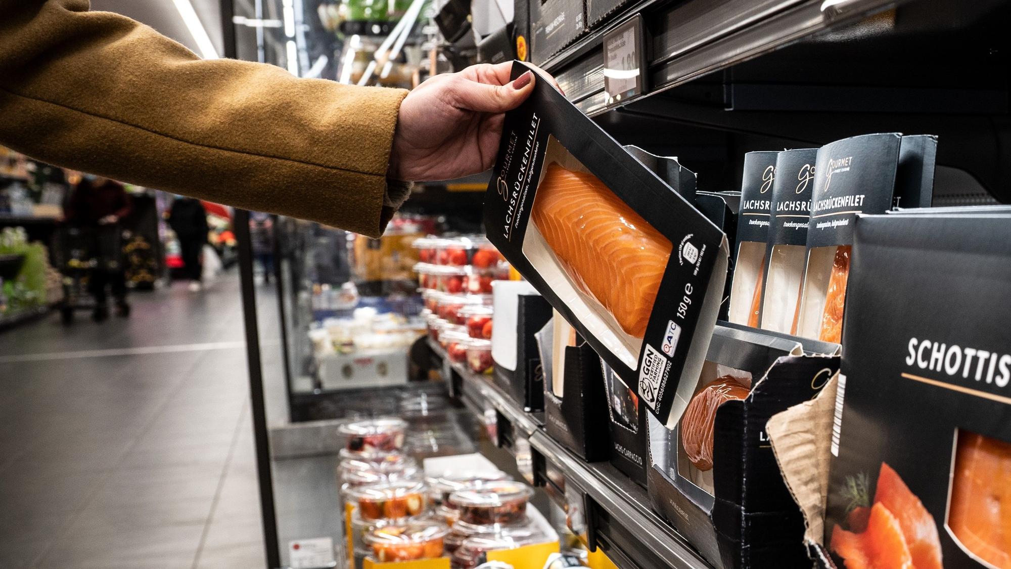 Aldi macht es vor, andere Discounter und Supermärkte werden nachziehen: Die Preise für viele Produkte steigen. Lebensmittel werden immer teurer. Eine Frau nimmt in unserem Archivbild von 2021 in einer Aldi-Filiale ein Produkt aus der Kühlung.