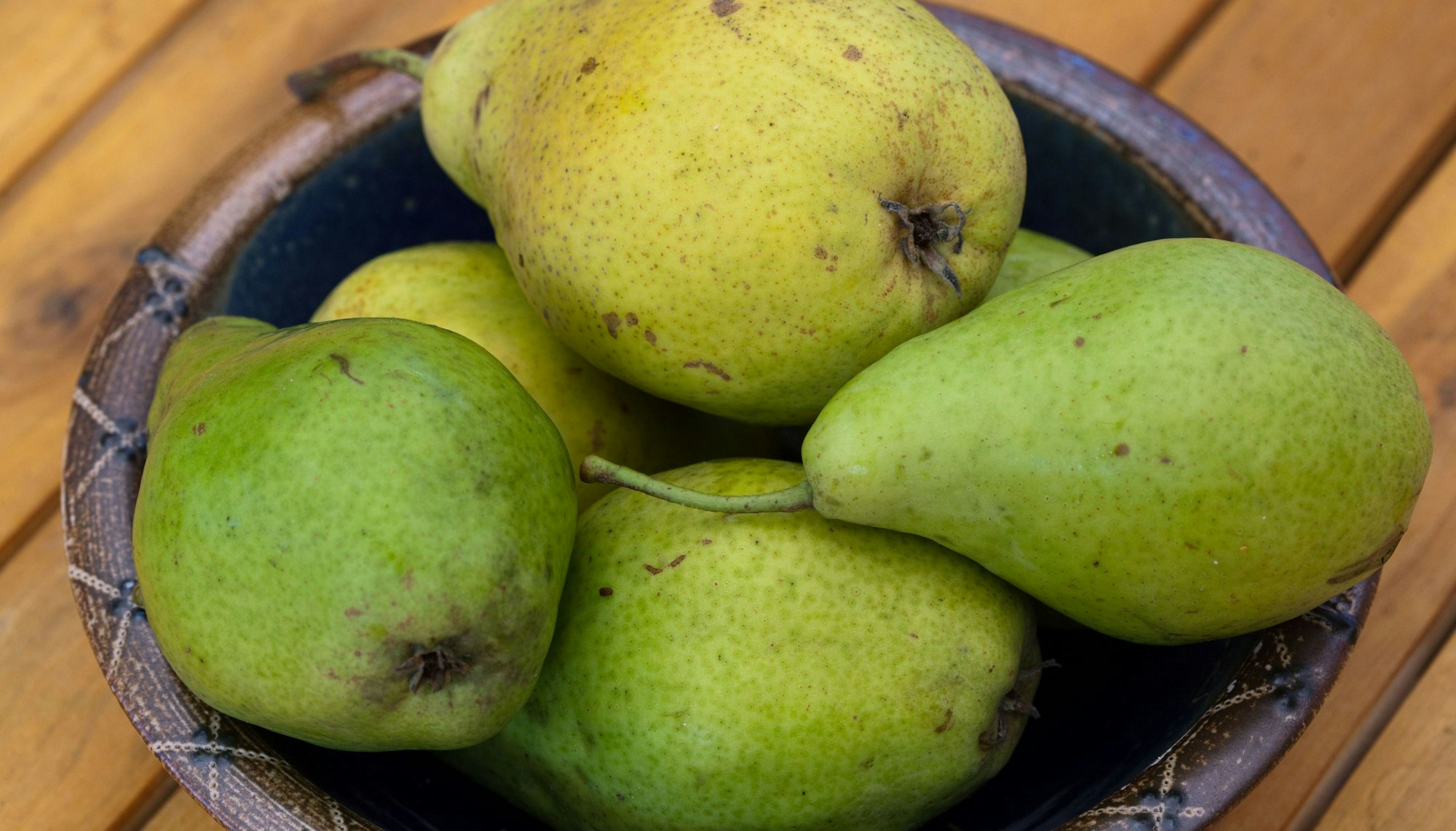 Birnen liegen in einer Schale auf einem Tisch.