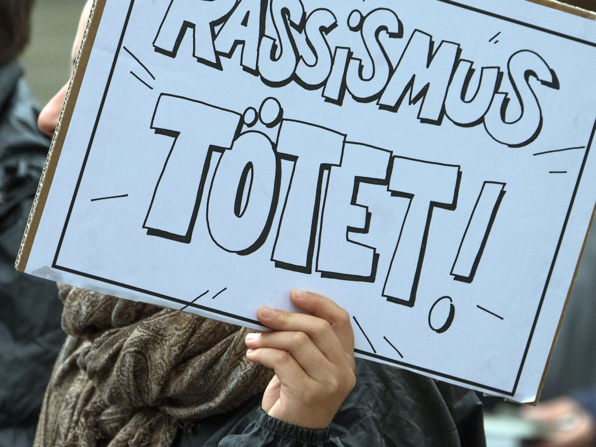Bei einer Demo zur Aufarbeitung des NSU-Komplexes zeigt eine Person am 11. Juli 2018 ein Plakat mit der Aufschrift: „Rassismus tötet!“