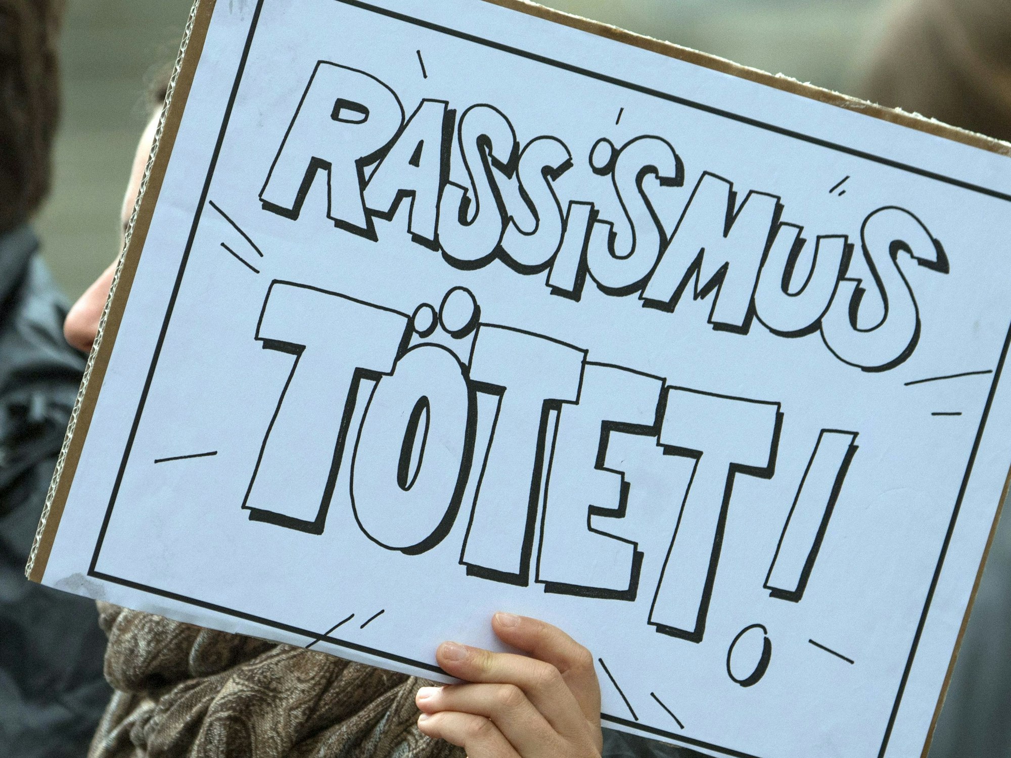 Bei einer Demo zur Aufarbeitung des NSU-Komplexes zeigt eine Person am 11. Juli 2018 ein Plakat mit der Aufschrift: „Rassismus tötet!“