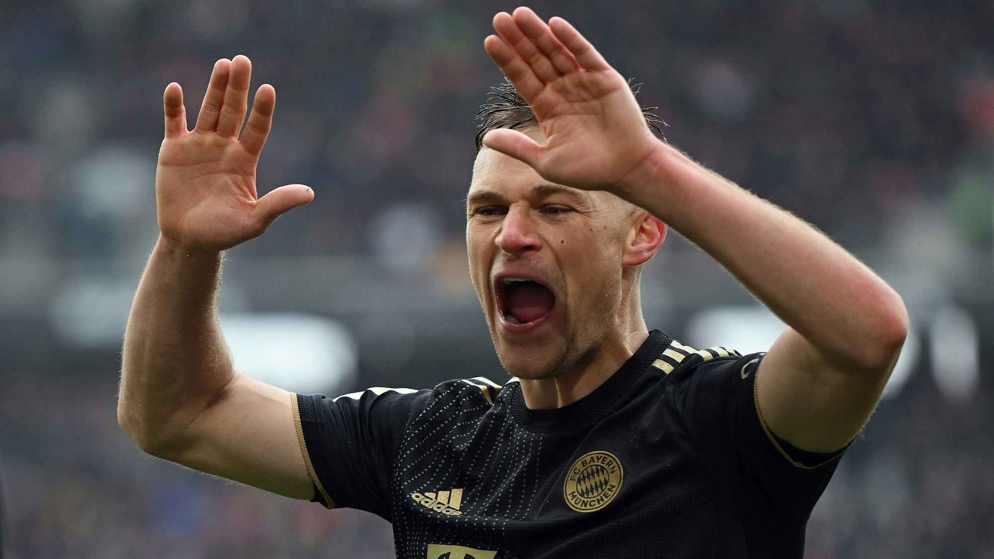 Joshua Kimmich vom FC Bayern München reißt jubelnd die Hände hoch.