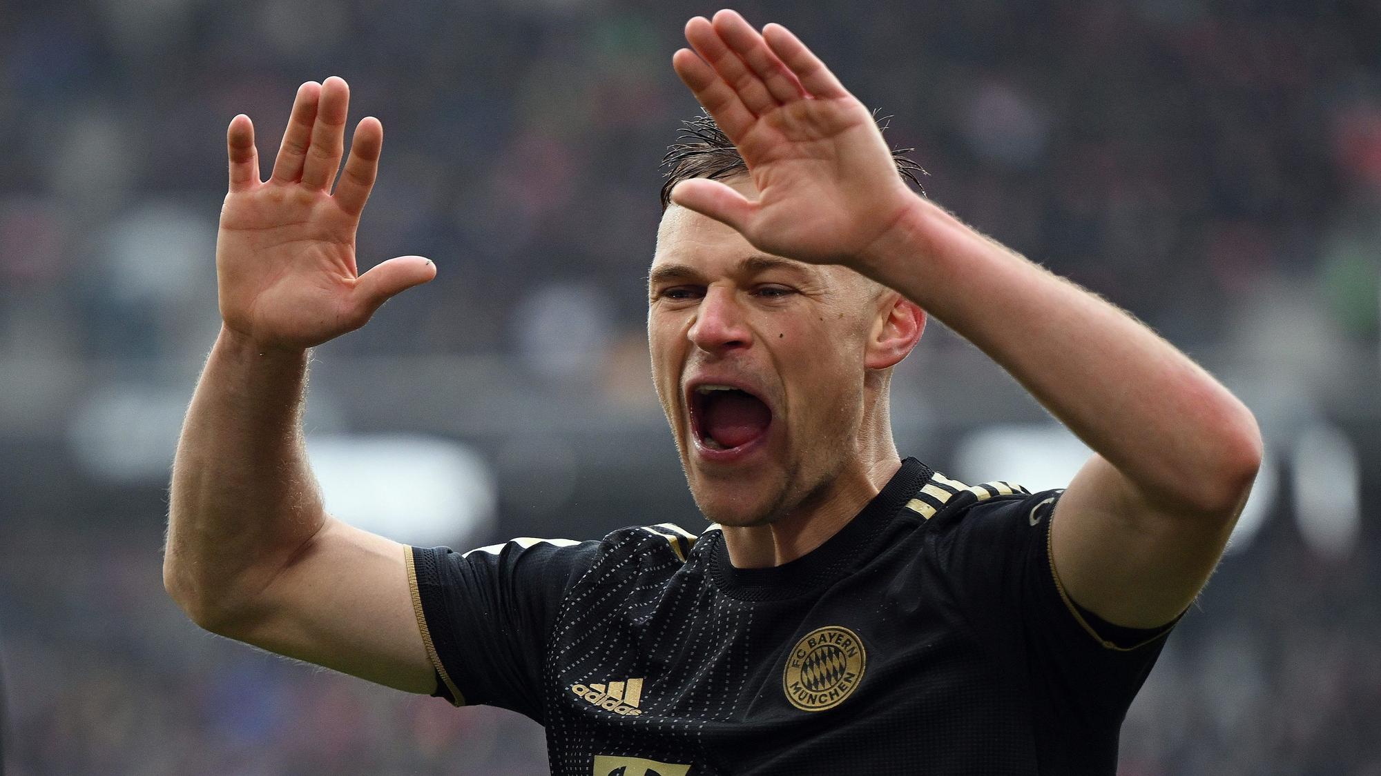 Joshua Kimmich vom FC Bayern München reißt jubelnd die Hände hoch.