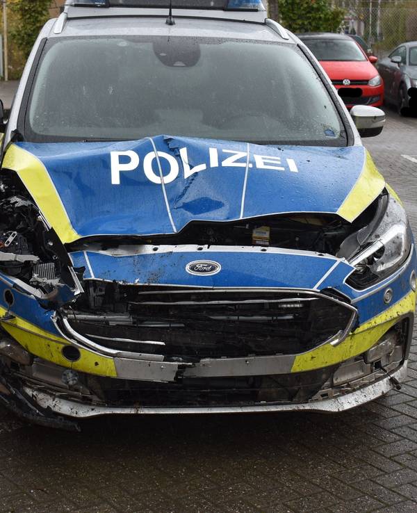 Die Motorhaube eines Streifenwagens ist eingedrückt und stark beschädigt.