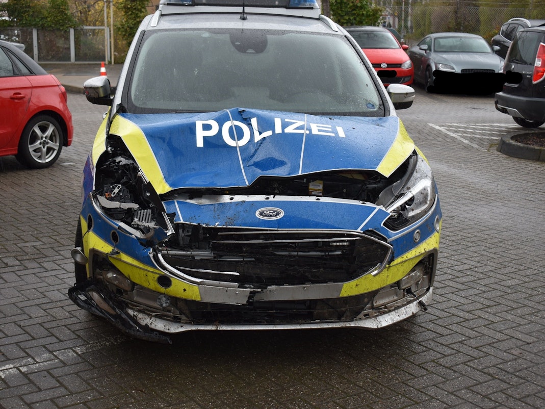 Die Motorhaube eines Streifenwagens ist eingedrückt und stark beschädigt.