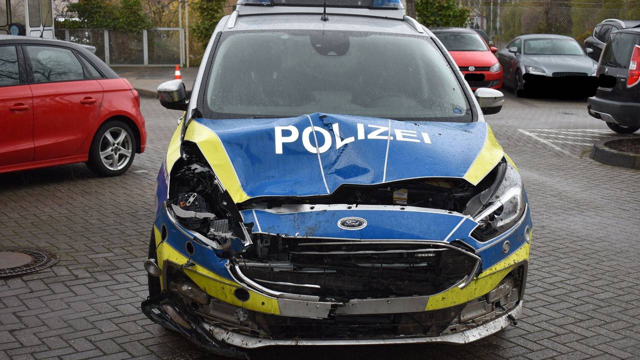 Die Motorhaube eines Streifenwagens ist eingedrückt und stark beschädigt.