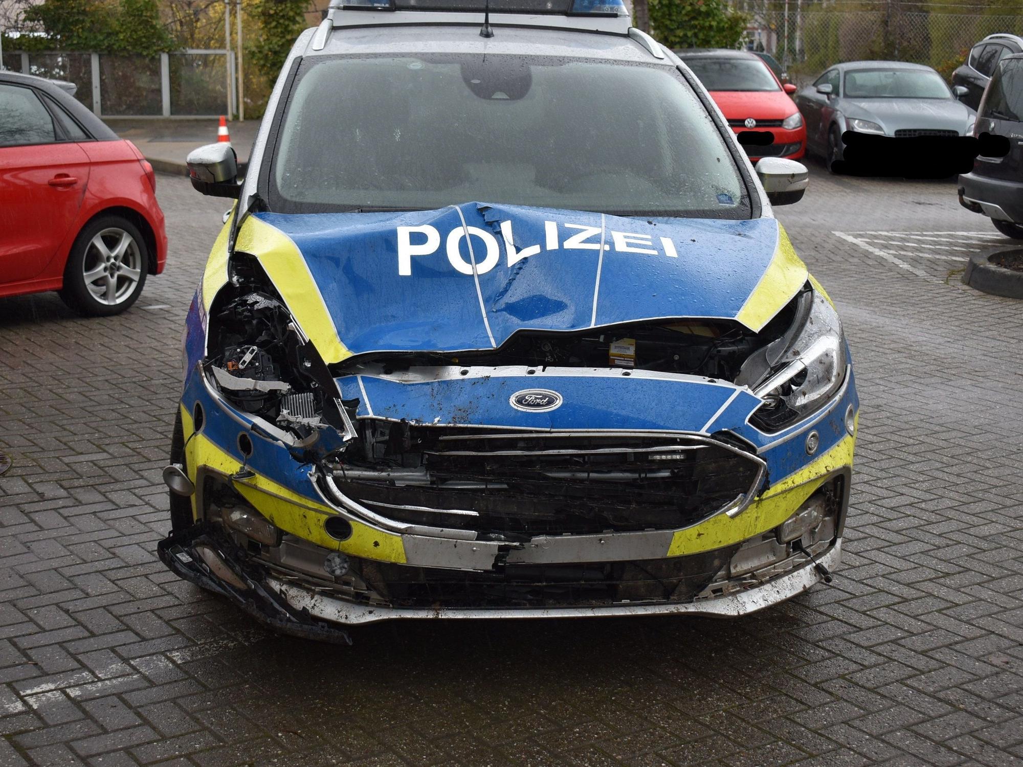 Die Motorhaube eines Streifenwagens ist eingedrückt und stark beschädigt.