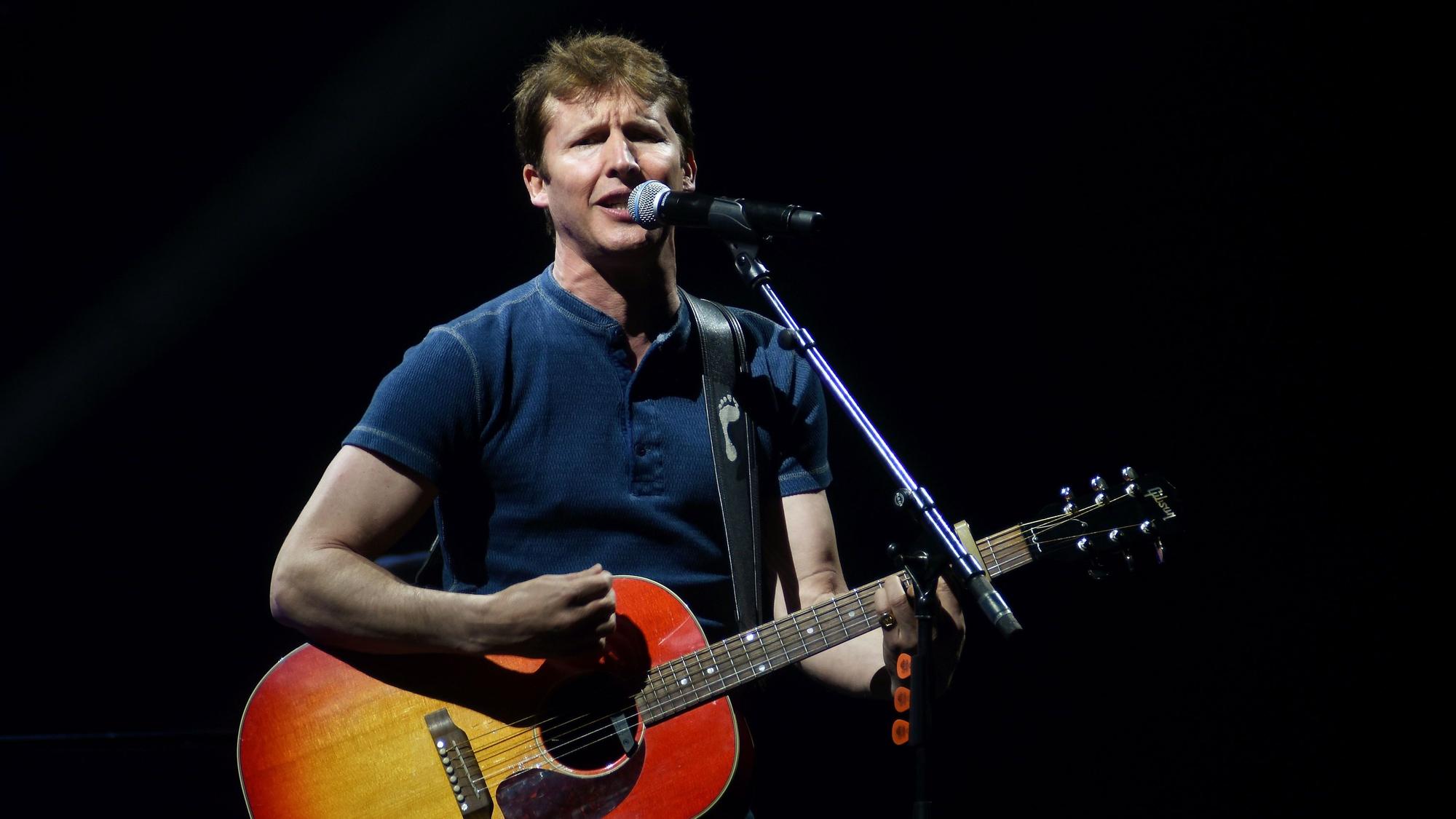 Emotionaler James Blunt singt mit seiner Gitarre in der Lanxess Arena in Köln.
