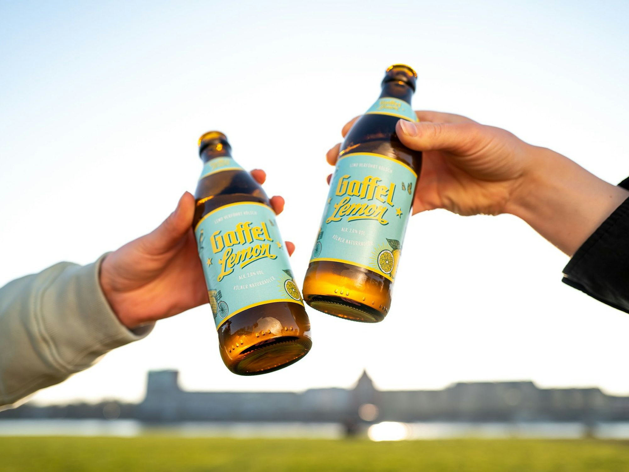 Zwei Personen stoßen mit Gaffel Lemon an. Das Gaffel gibt es jetzt auch aus der kultigen 0,33l-Euroflasche. Bisher wurde das Biermixgetränk in Dosen verkauft.
