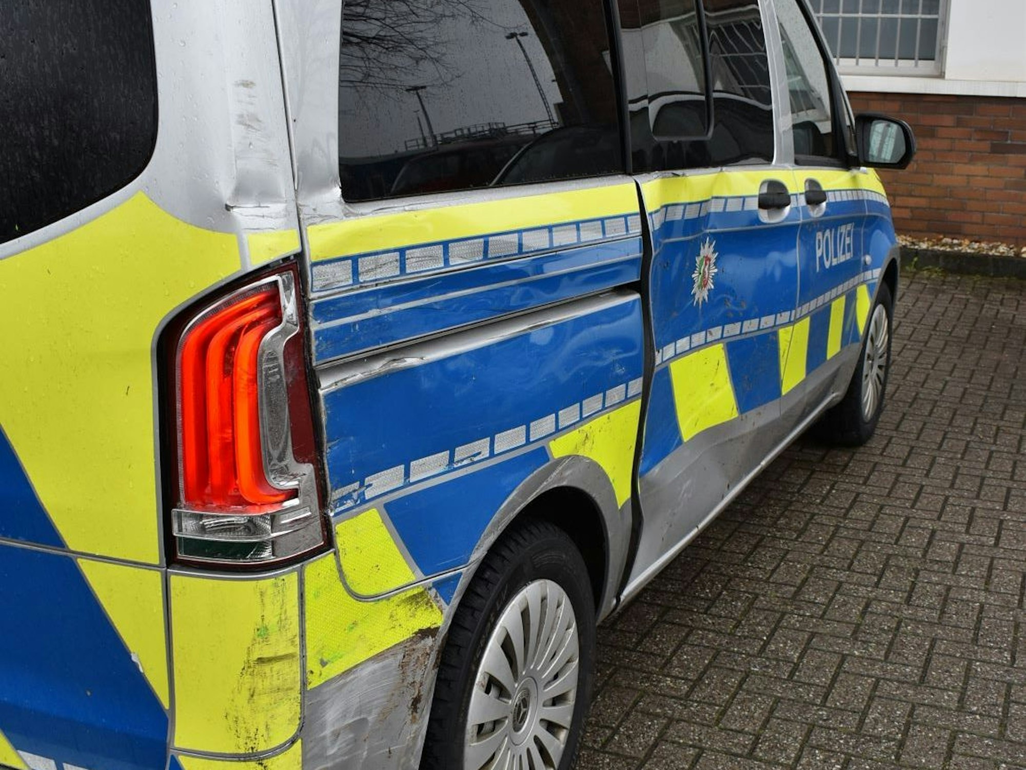 Ein Polizeifahrzeug ist an der einen Seite stark beschädigt.