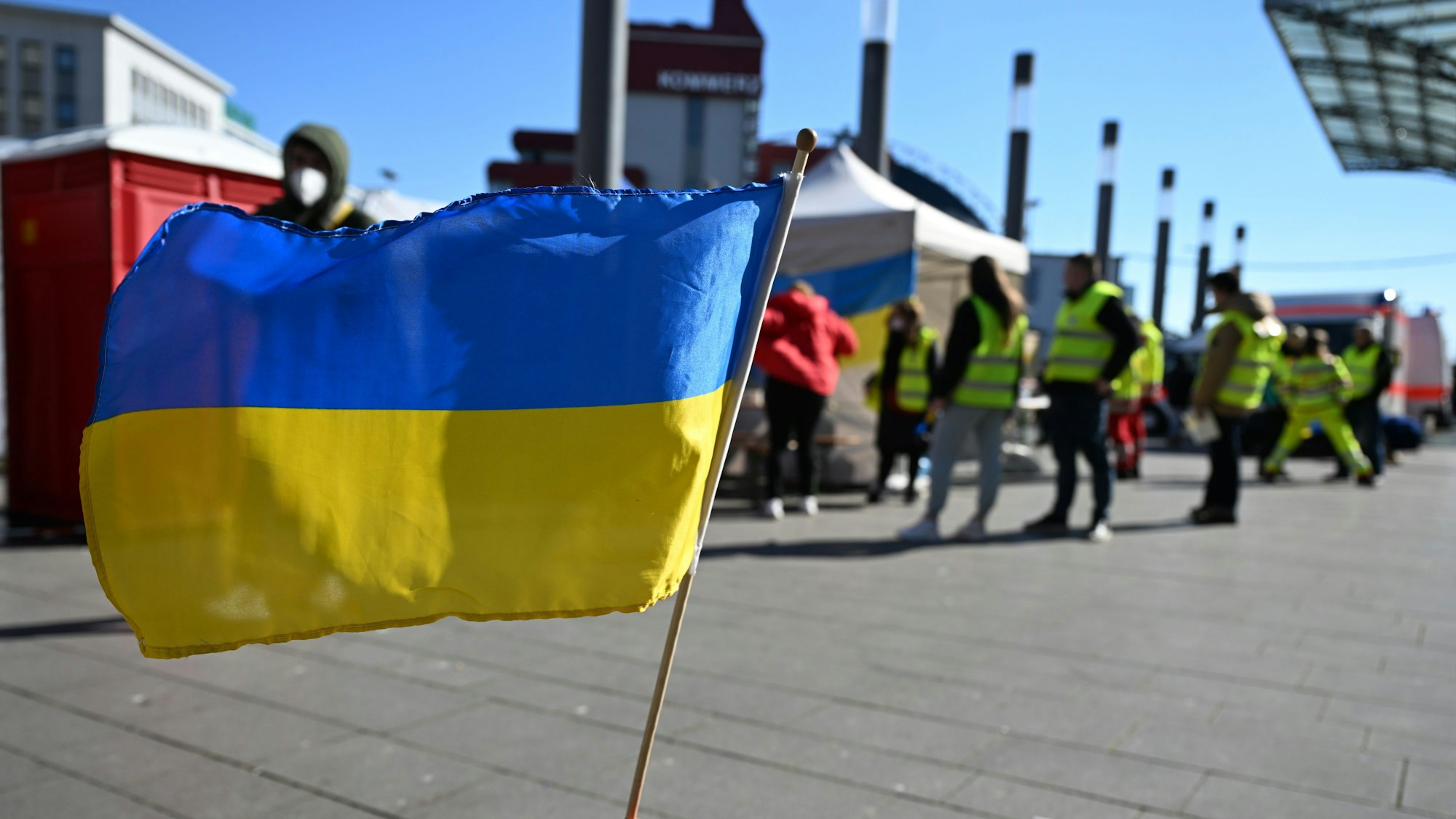 Eine ukrainische Flagge vor der Anlaufstelle für Geflüchtete aus der Ukraine am Kölner Hauptbahnhof