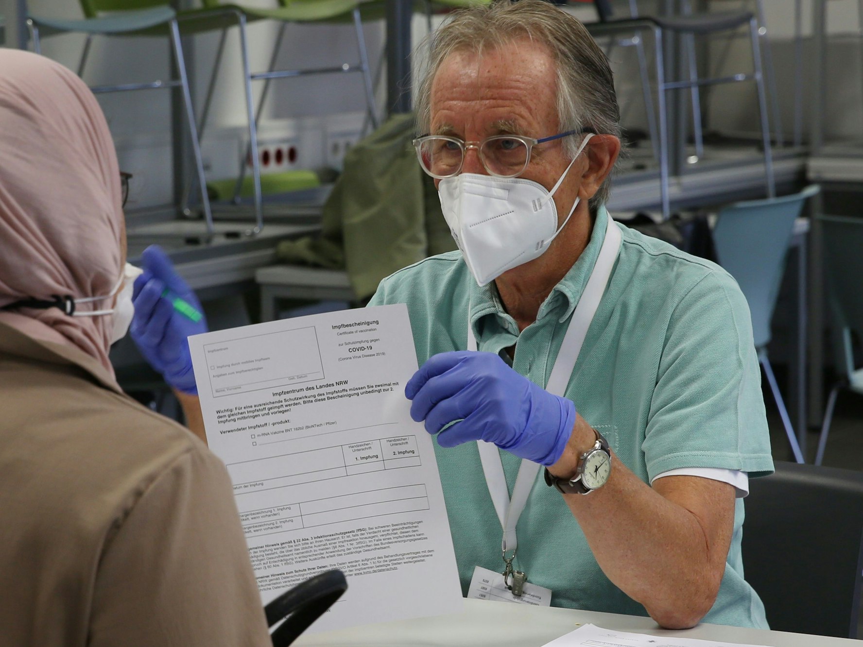 Dr. Eckhard Dierlich zeigt einer Frau ein Formular.