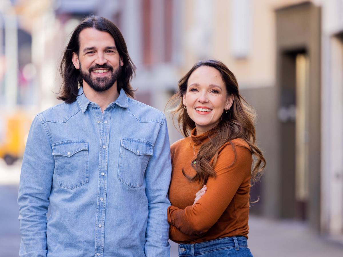 Carolin Kebekus, Comedian, und ihr Bruder David Kebekus, Autor, stehen in einer Gasse.