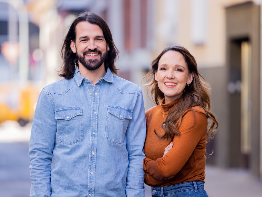 Carolin Kebekus, Comedian, und ihr Bruder David Kebekus, Autor, stehen in einer Gasse.