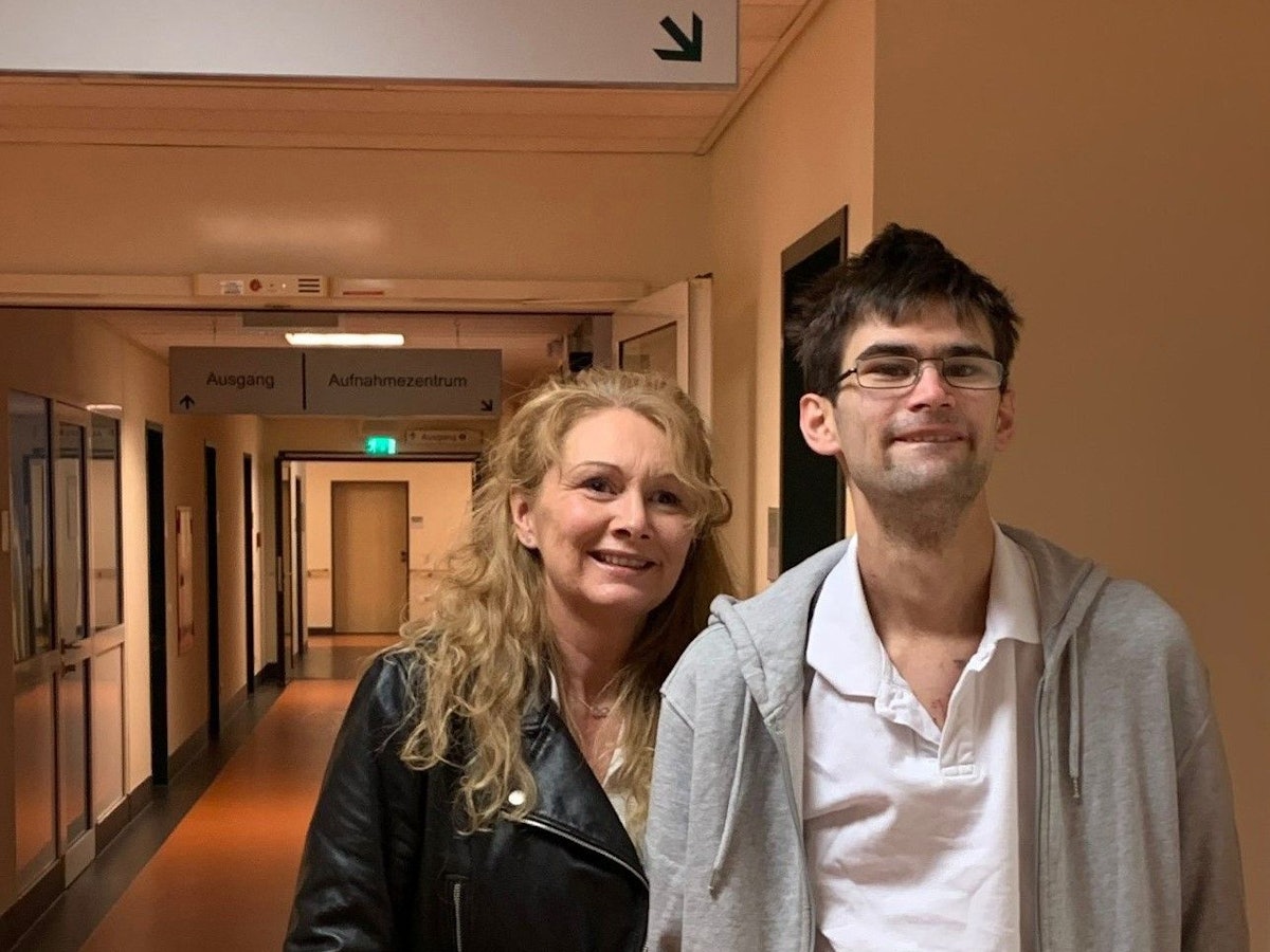 Der 27-jährige Christopher und seine Mutter Gabriele stehen im Flur des Helios Klinikums in Siegburg.
