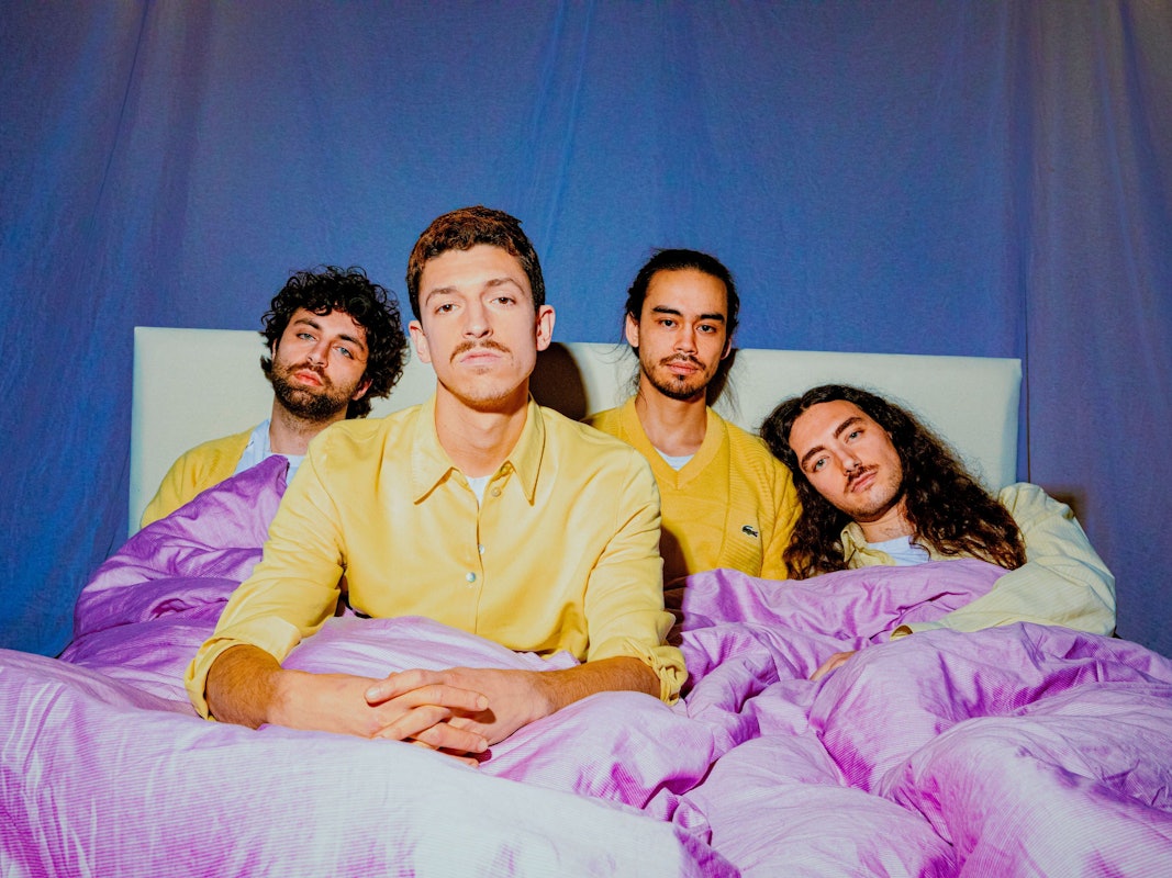 Die Bandmitglieder von Tigermilch posieren im Bett. Mit ihrem eigenen, speziellen Stil erobern die Kölner die Musikwelt.