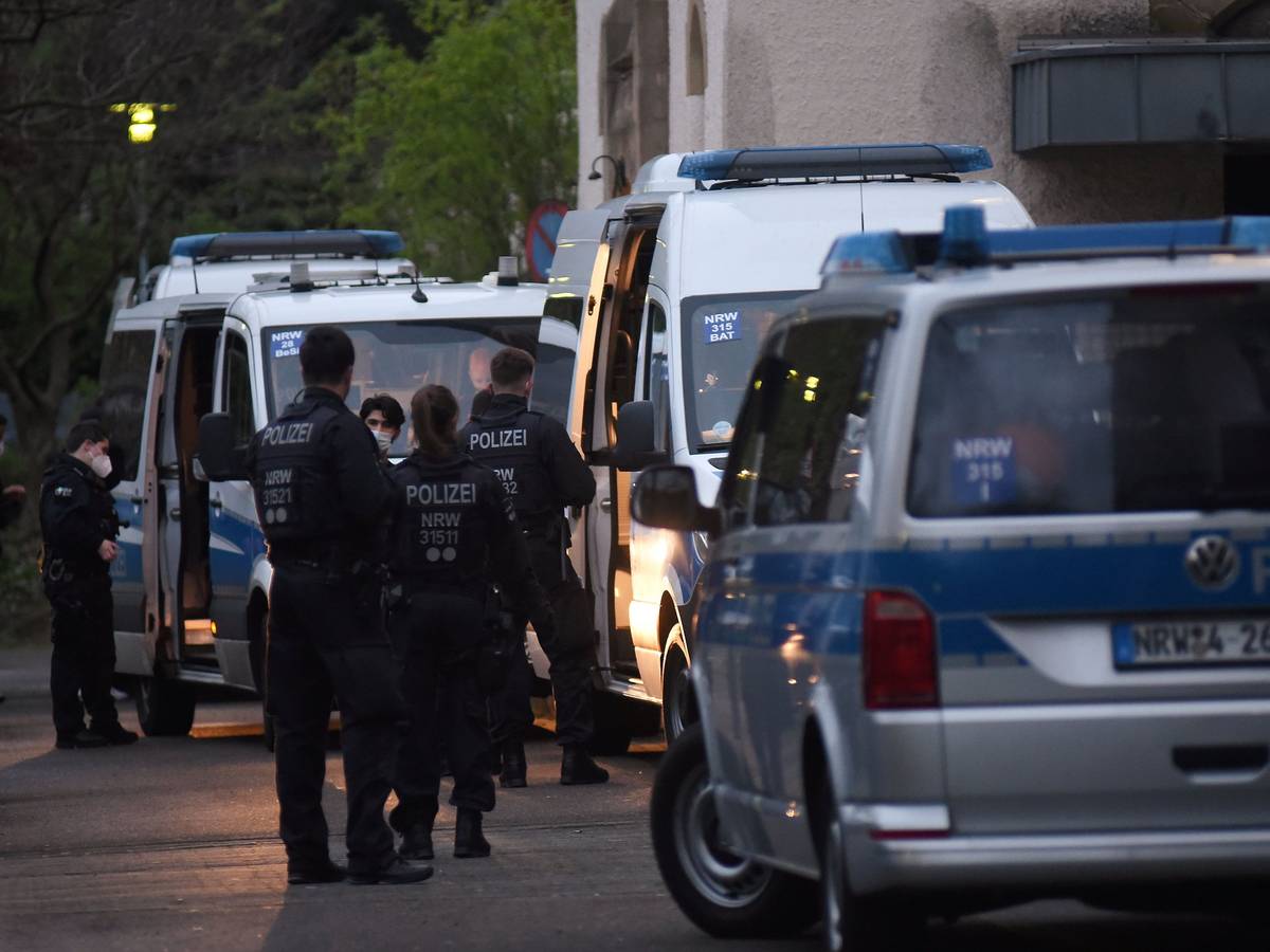 Polizeifahrzeuge und Einsatzkräfte stehen vor einem Kölner Flüchtlingsheim.