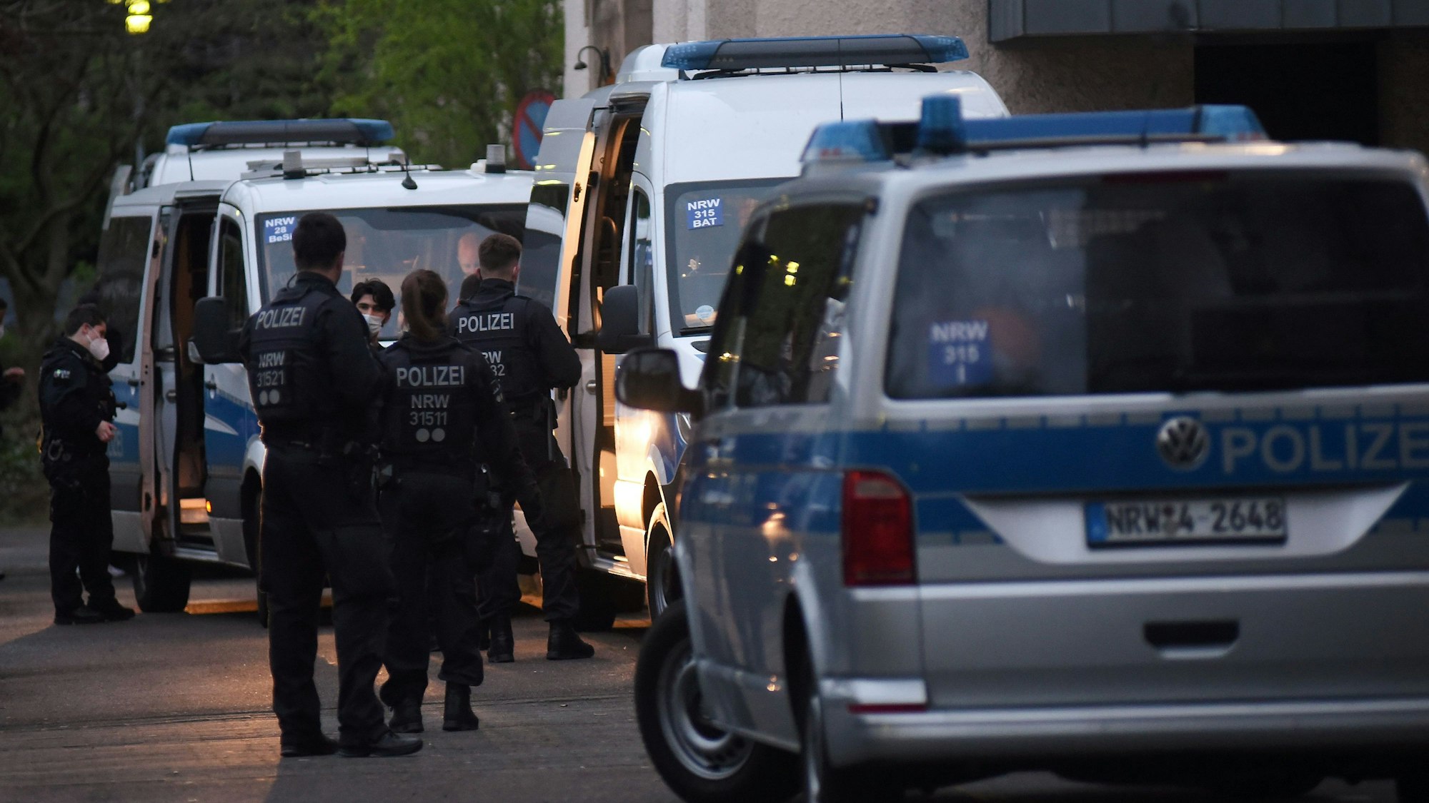 Polizeifahrzeuge und Einsatzkräfte stehen vor einem Kölner Flüchtlingsheim.