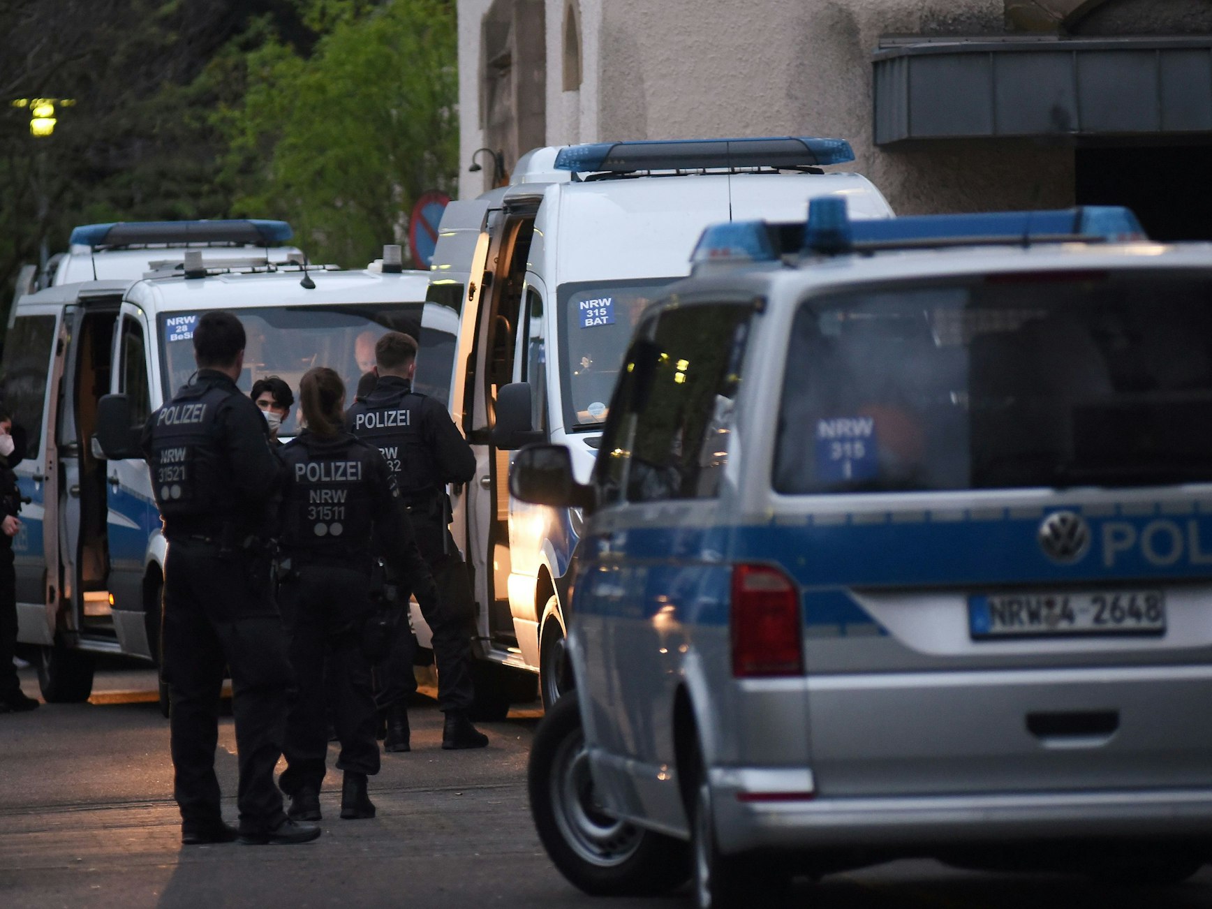 Polizeifahrzeuge und Einsatzkräfte stehen vor Häusern.