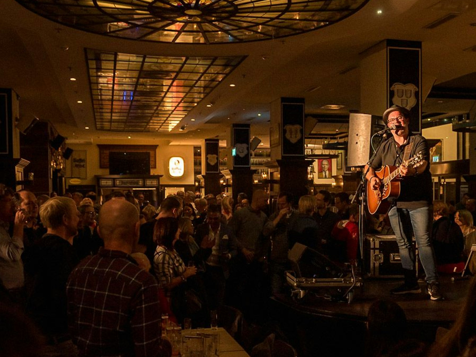 Björn Heuser steht mit seiner Gitarre auf der Bühne.