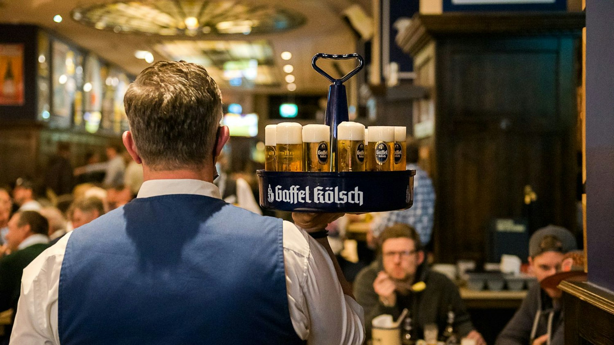 Ein Kellner serviert Bier.