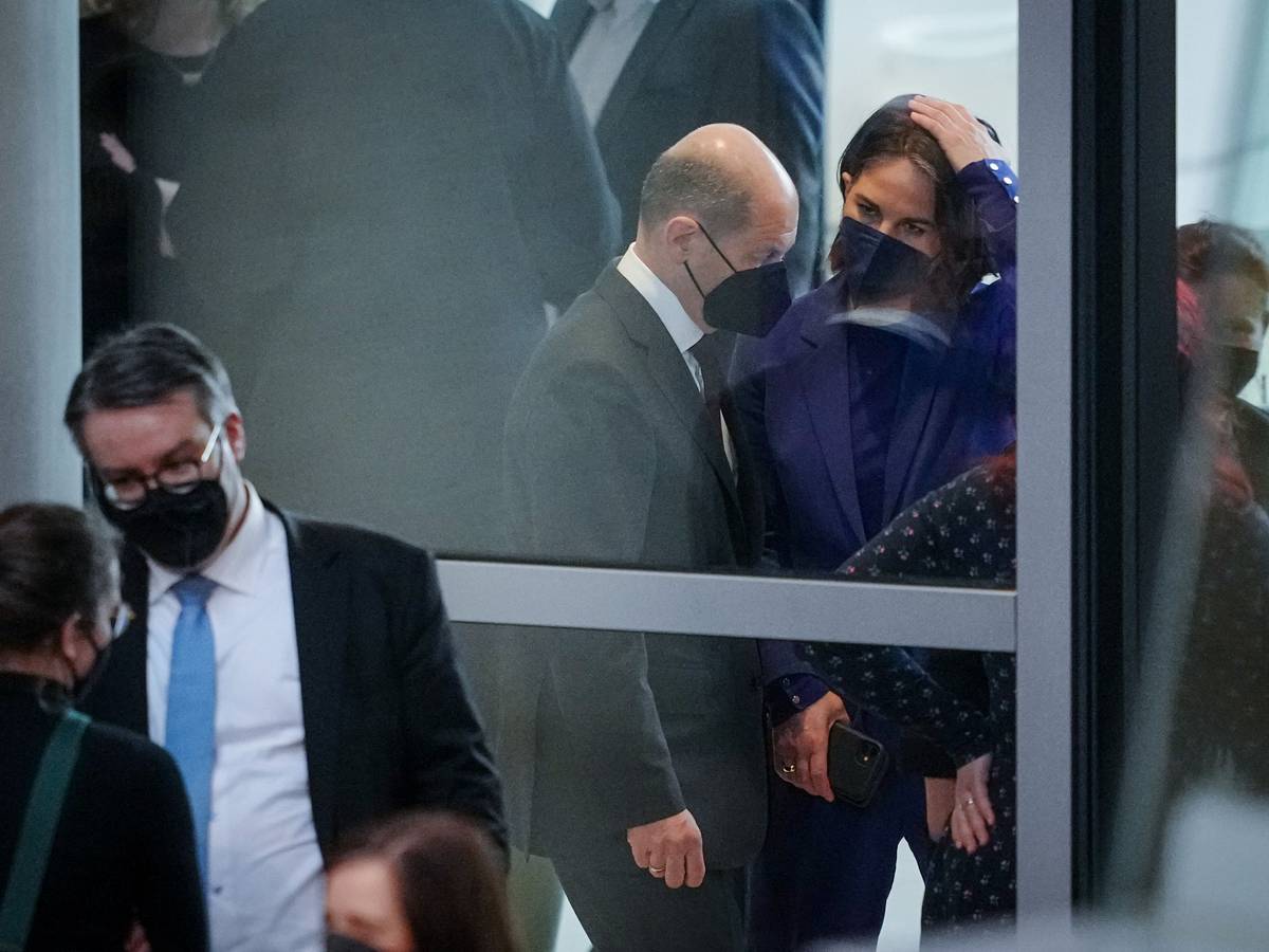 Bundeskanzler Olaf Scholz (SPD) unterhalten sich im Foyer an Rande der Sitzung des Bundestags.