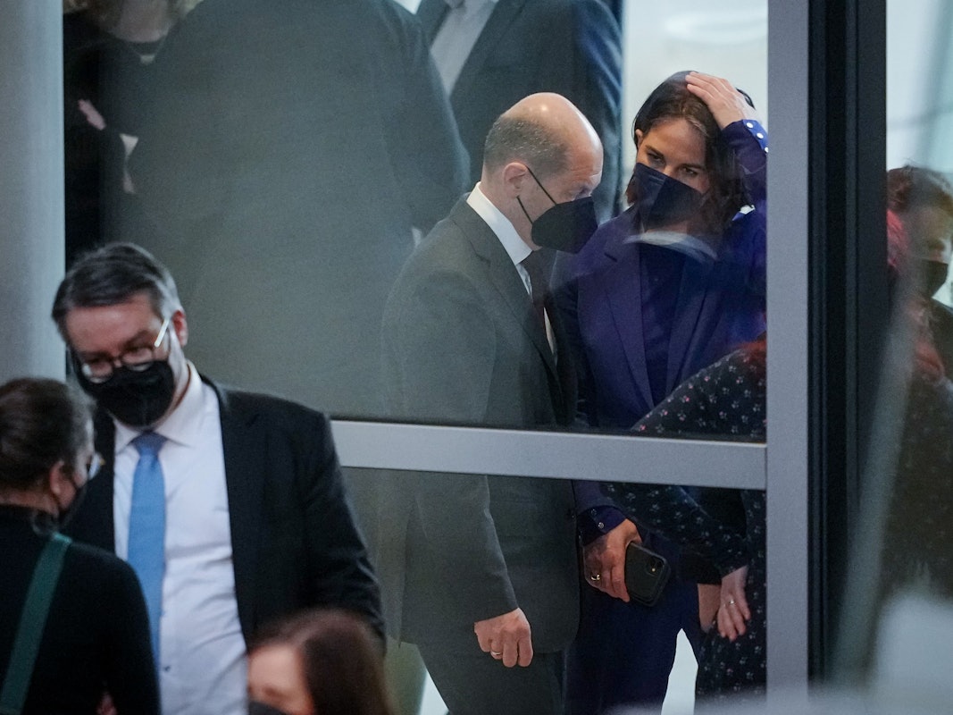 Bundeskanzler Olaf Scholz (SPD) unterhalten sich im Foyer an Rande der Sitzung des Bundestags.