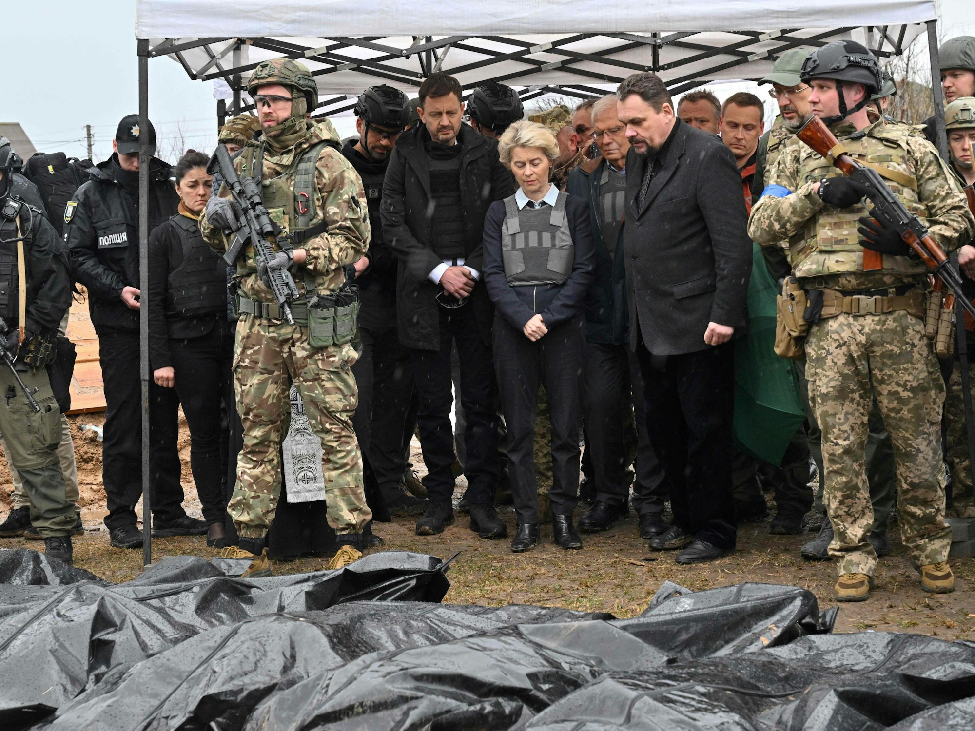 Ursula von der Leyen (Mitte) in einem Moment der Andacht. Die EU-Kommissionspräsidentin ist die erste westliche Spitzenpolitikerin, die sich ein Bild vom Grauen in Butscha macht. Das Foto vom 8. April 2022 zeigt sie an einem Massengrab.