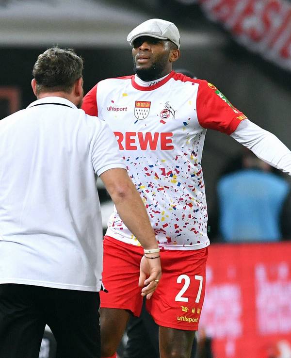 Anthony Modeste bejubelt sein Tor mit der Mütze von Steffen Baumgart auf dem Kopf.