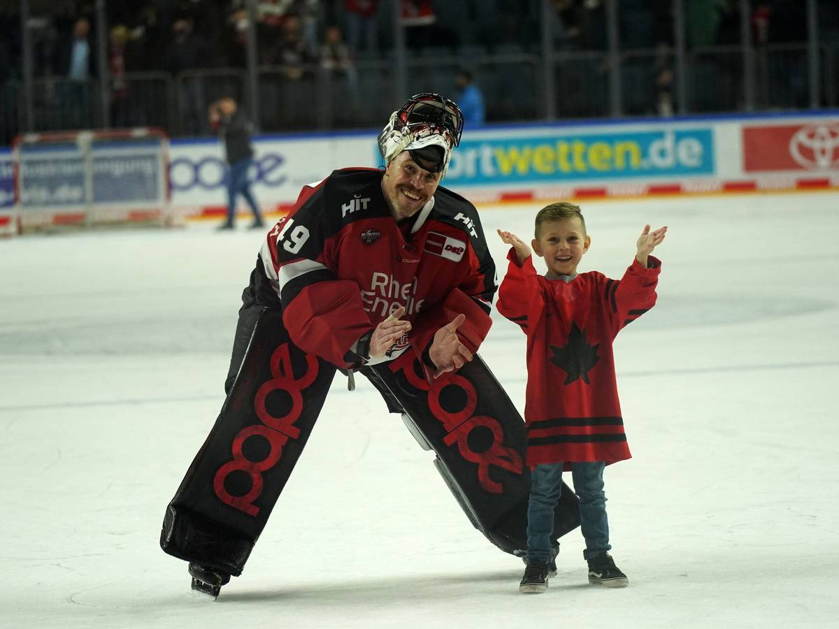 Justin Pogge (Kölner Haie) auf dem Eis mit seinem Kind.