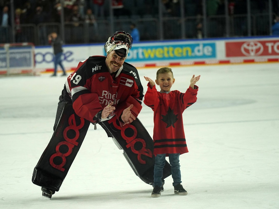 Justin Pogge (Kölner Haie) auf dem Eis mit seinem Kind.