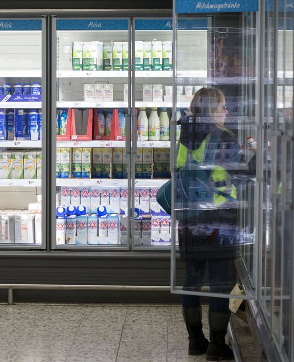 Eine Frau steht in einem Einkaufsmarkt vor einem Kühlregal mit Milchprodukten, Symbolfoto, aufgenommen im Januar 2015.