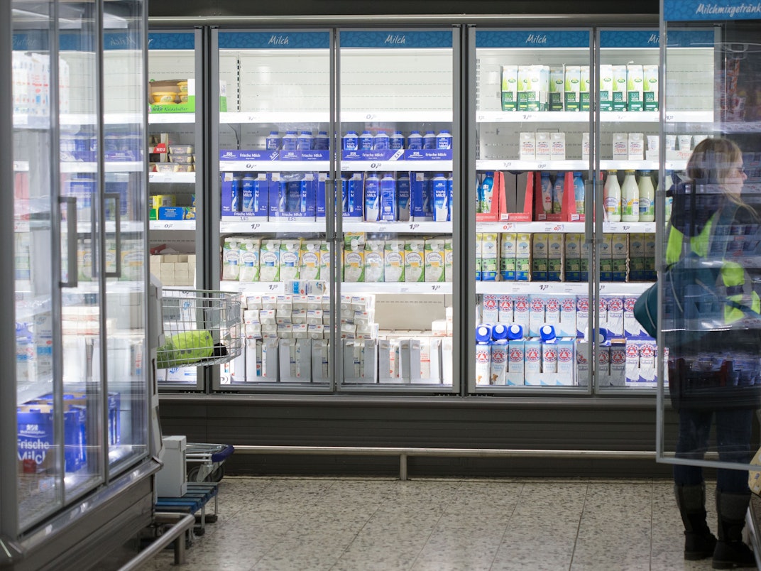 Eine Frau steht in einem Einkaufsmarkt vor einem Kühlregal mit Milchprodukten, Symbolfoto, aufgenommen im Januar 2015.