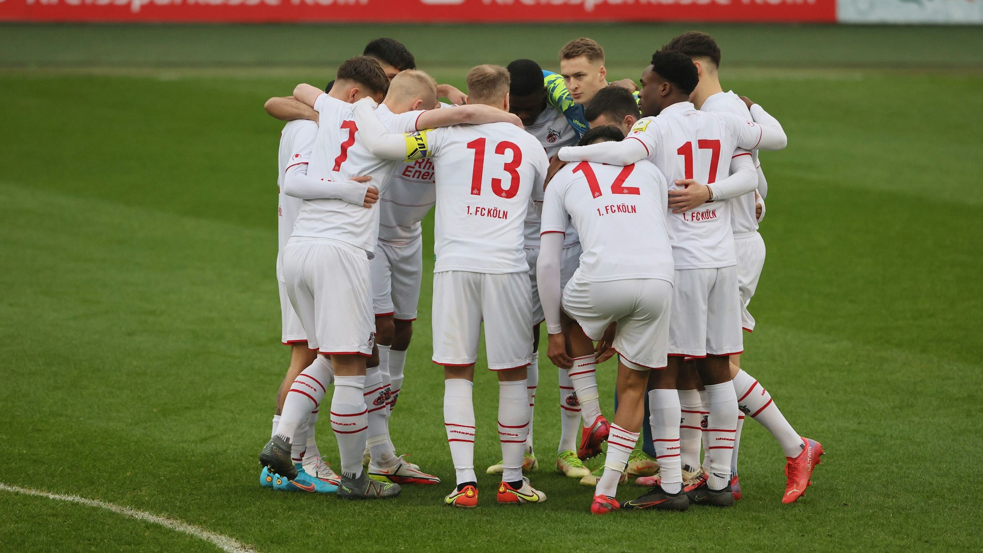 Die Mannschaft der U21 des 1. FC Köln bildet einen Spielerkreis.