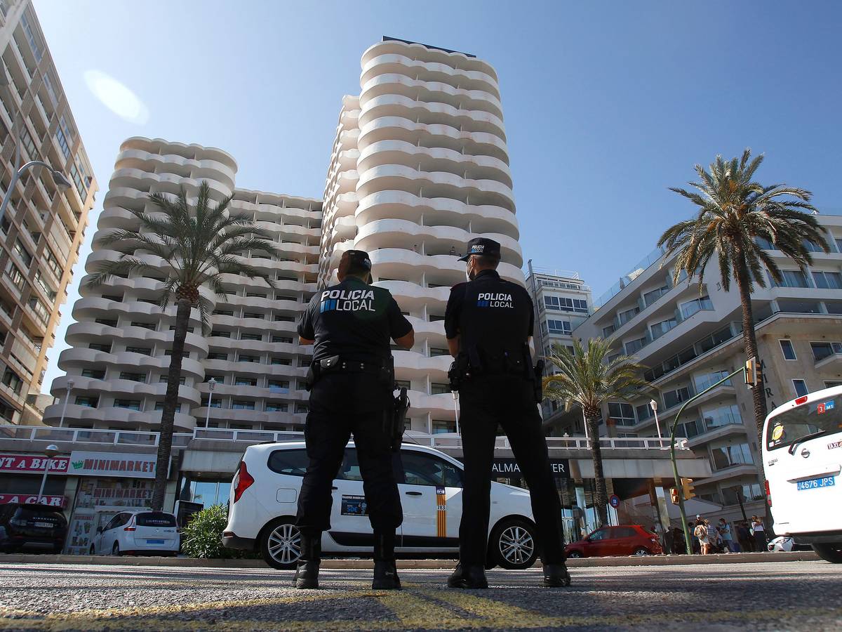 Zwei Polizisten stehen im Einsatz vor einem spanischen Hotel.