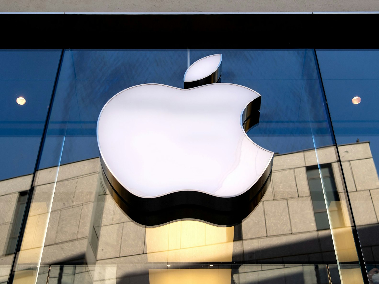 Das Logo des Technologie-Unternehmens Apple ist an einer Gebäudefassade angebracht.