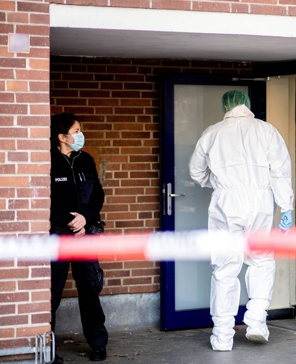 Ein Ermittler der Spurensicherung betritt ein Mehrfamilienhaus.