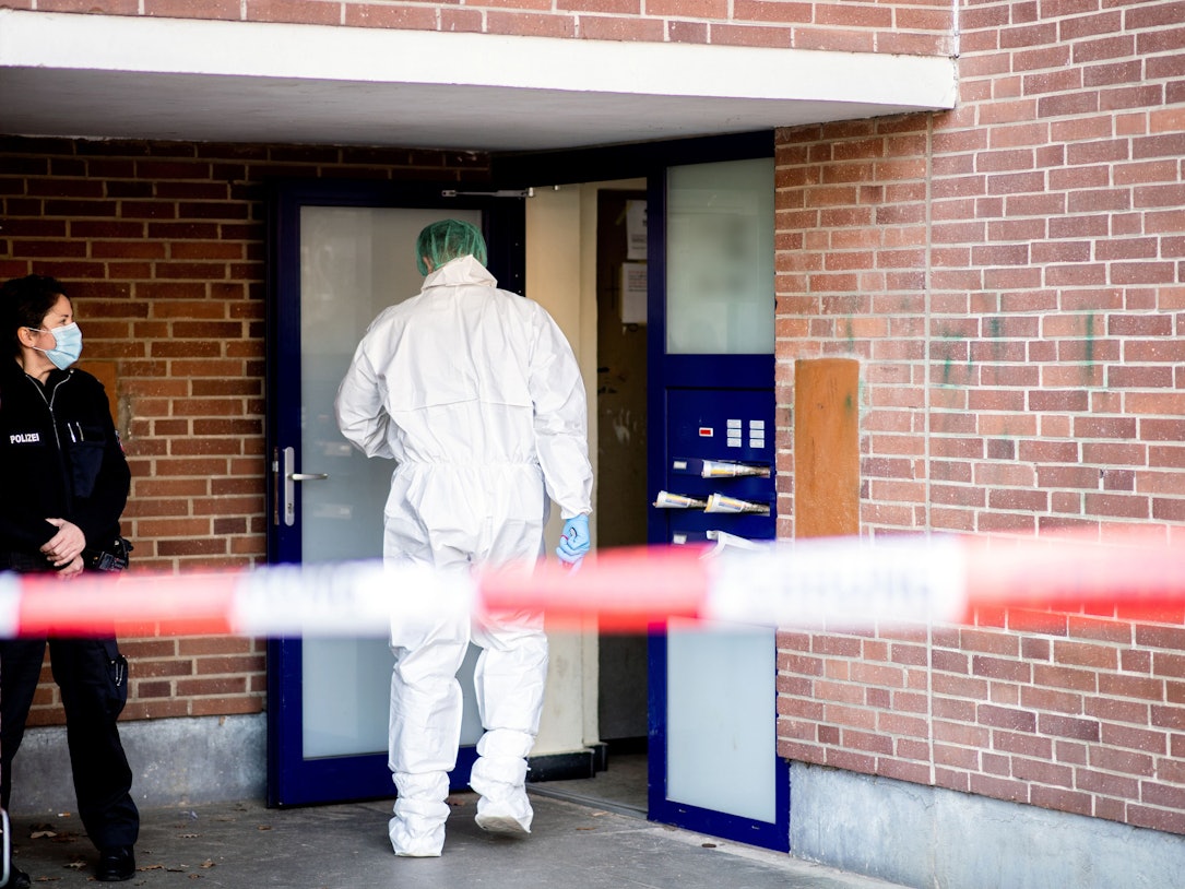 Ein Ermittler der Spurensicherung betritt ein Mehrfamilienhaus.