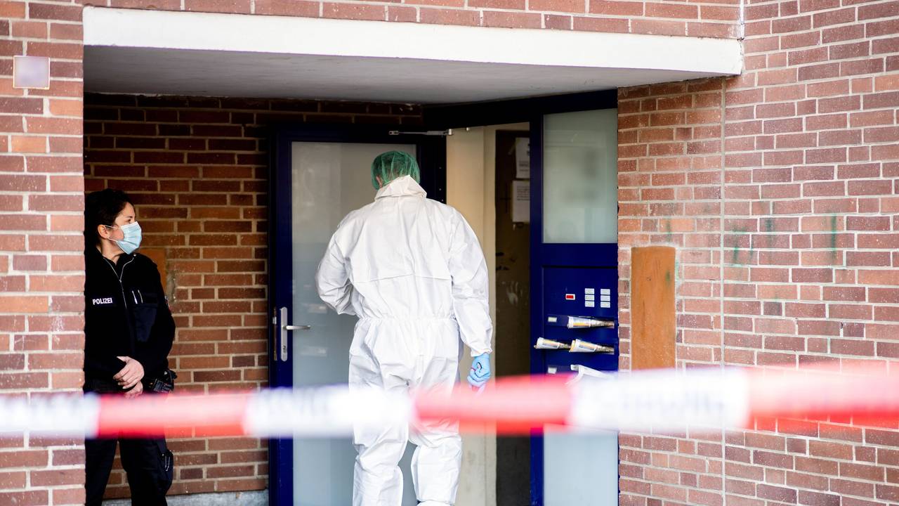 Ein Ermittler der Spurensicherung betritt ein Mehrfamilienhaus.