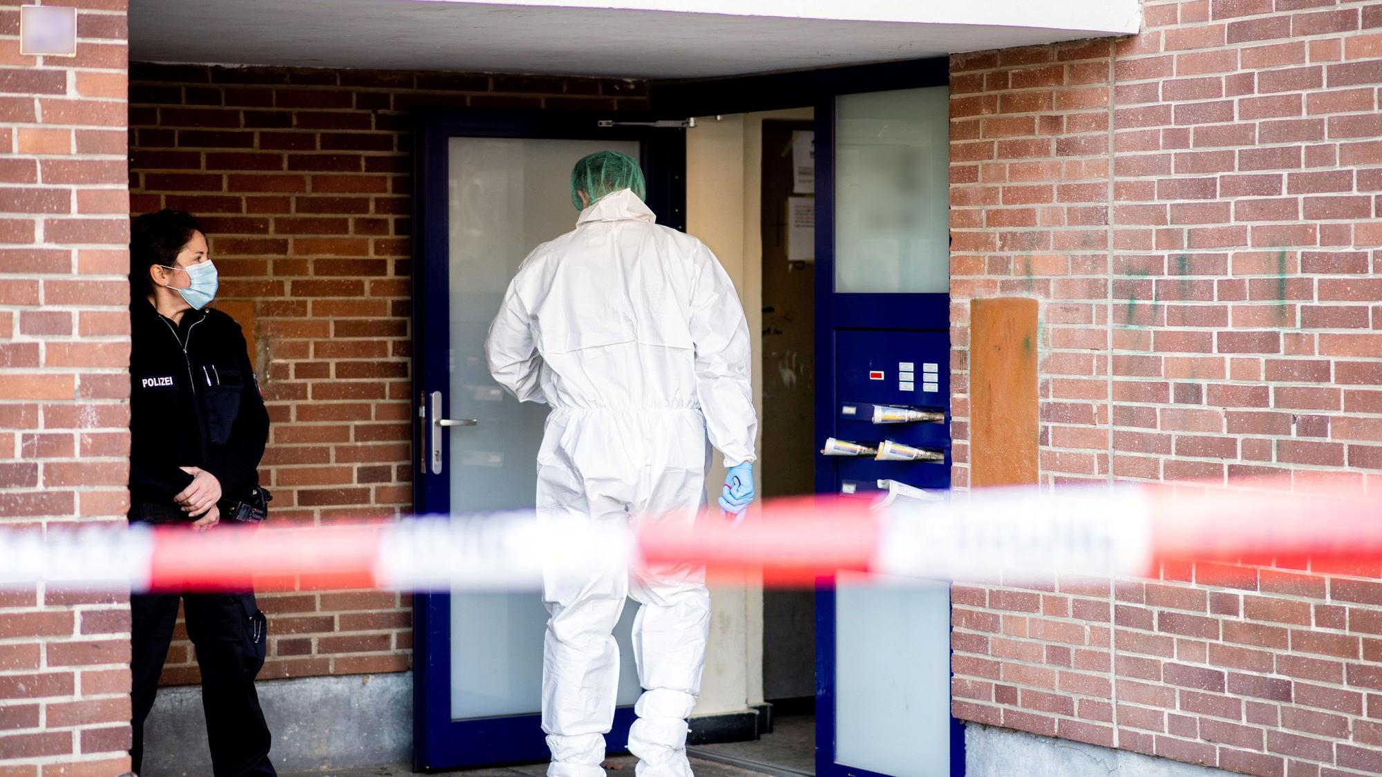 Ein Ermittler der Spurensicherung betritt ein Mehrfamilienhaus.