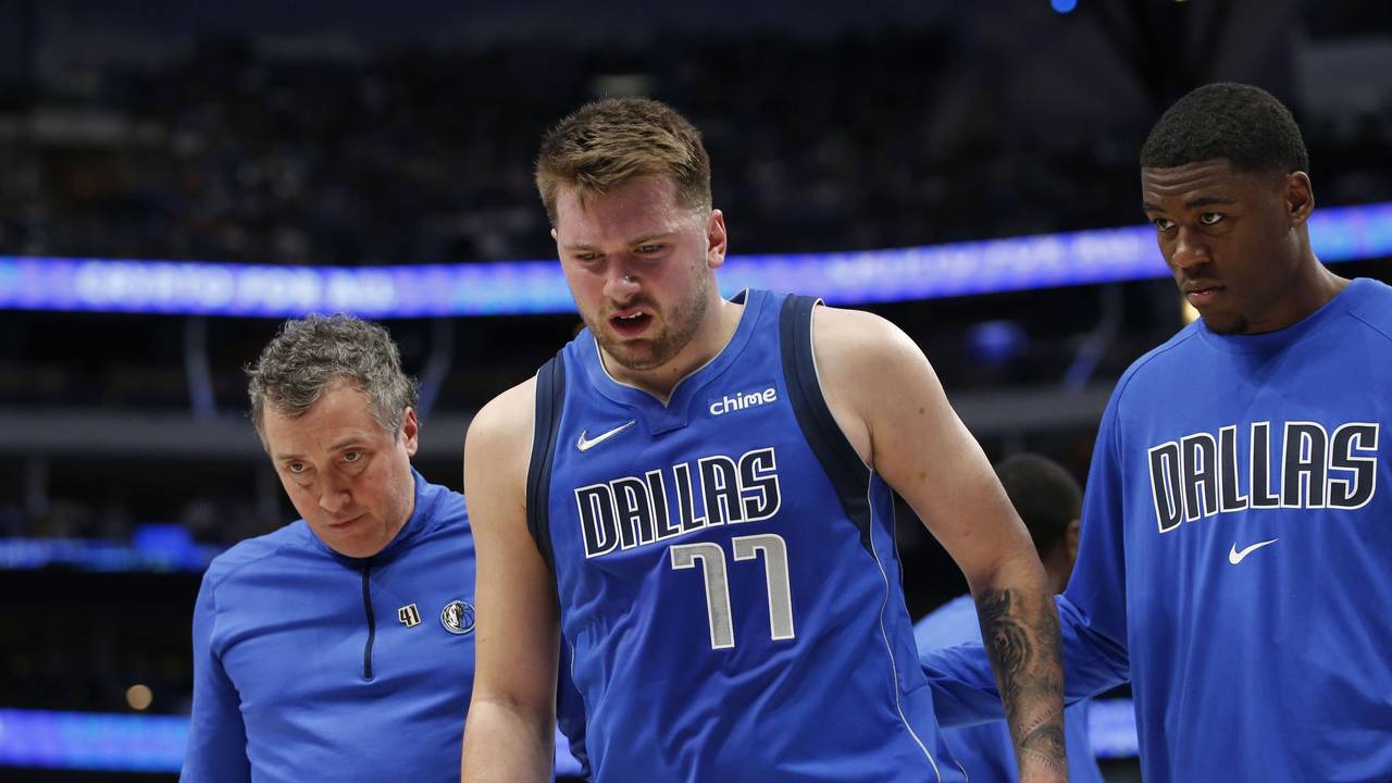 Luka Doncic (Mitte) von den Dallas Mavericks verlässt den Platz nach einer Verletzung in Begleitung von Casey Smith and Moses Wright.