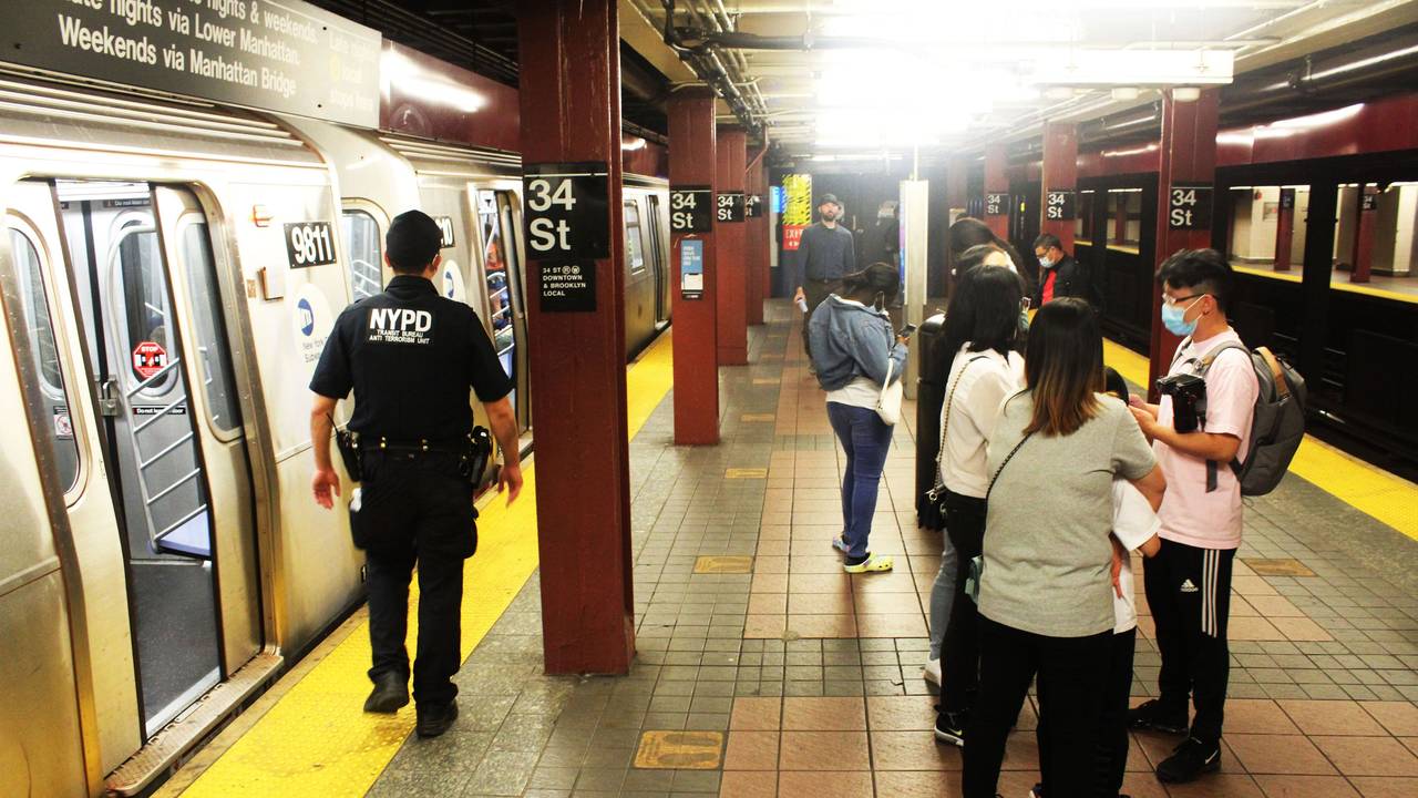 Das undatierte Symbolfoto zeigt eine U-Bahn-Station mit zwei haltenden Bahnen und mehreren Menschen, darunter ein Polizist in Uniform.