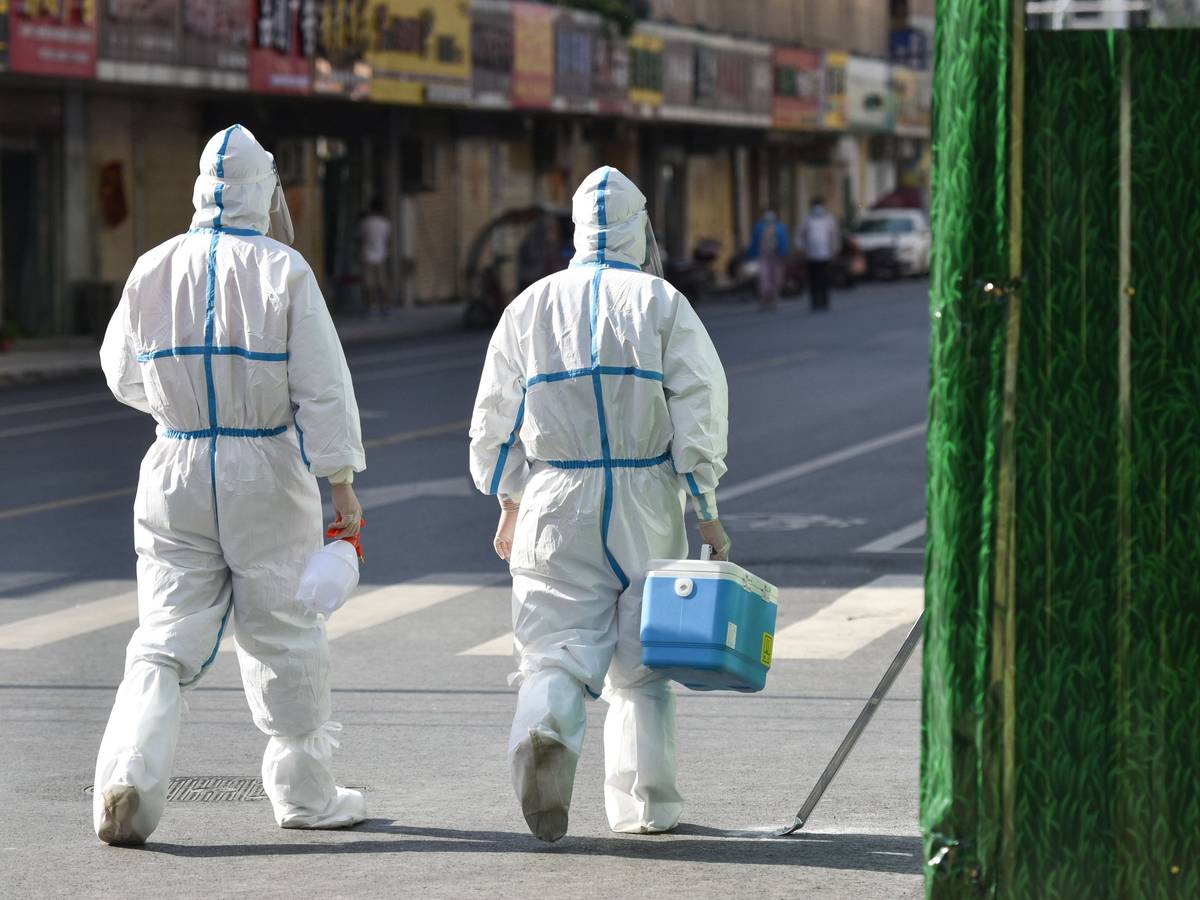 Medizinisches Personal in Schutzkleidung (PSA) geht am 9. April 2022 auf einer Straße in einem abgeriegelten Bereich. China verfolgt rigoros eine Null-Covid-Strategie und hat Shanghai abgeriegelt.