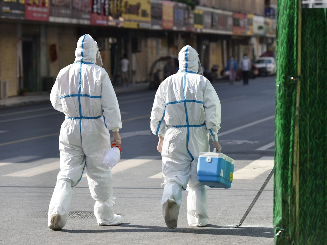 Medizinisches Personal in Schutzkleidung (PSA) geht am 9. April 2022 auf einer Straße in einem abgeriegelten Bereich. China verfolgt rigoros eine Null-Covid-Strategie und hat Shanghai abgeriegelt.